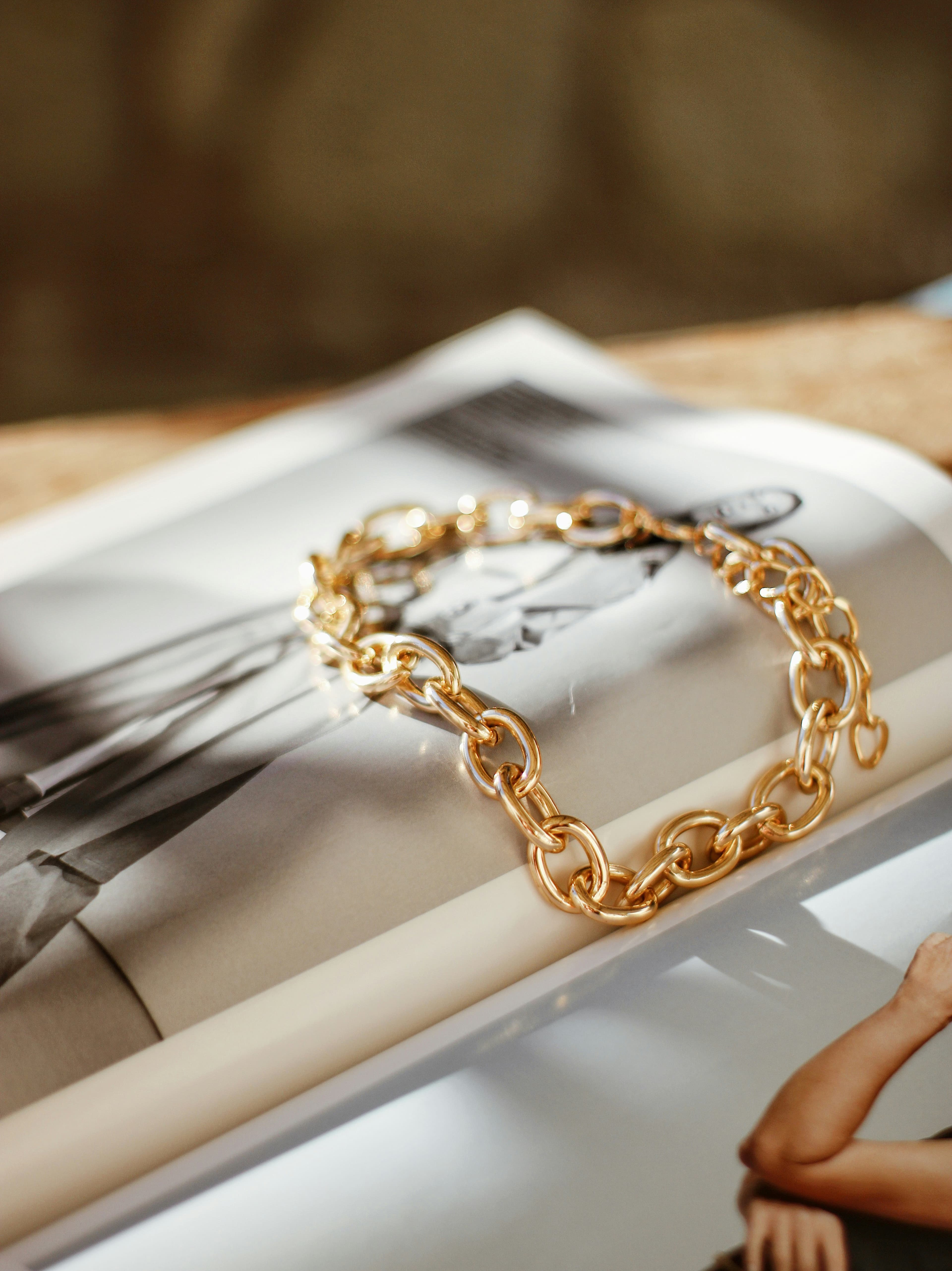 A gold chain resting beside a drawing on paper