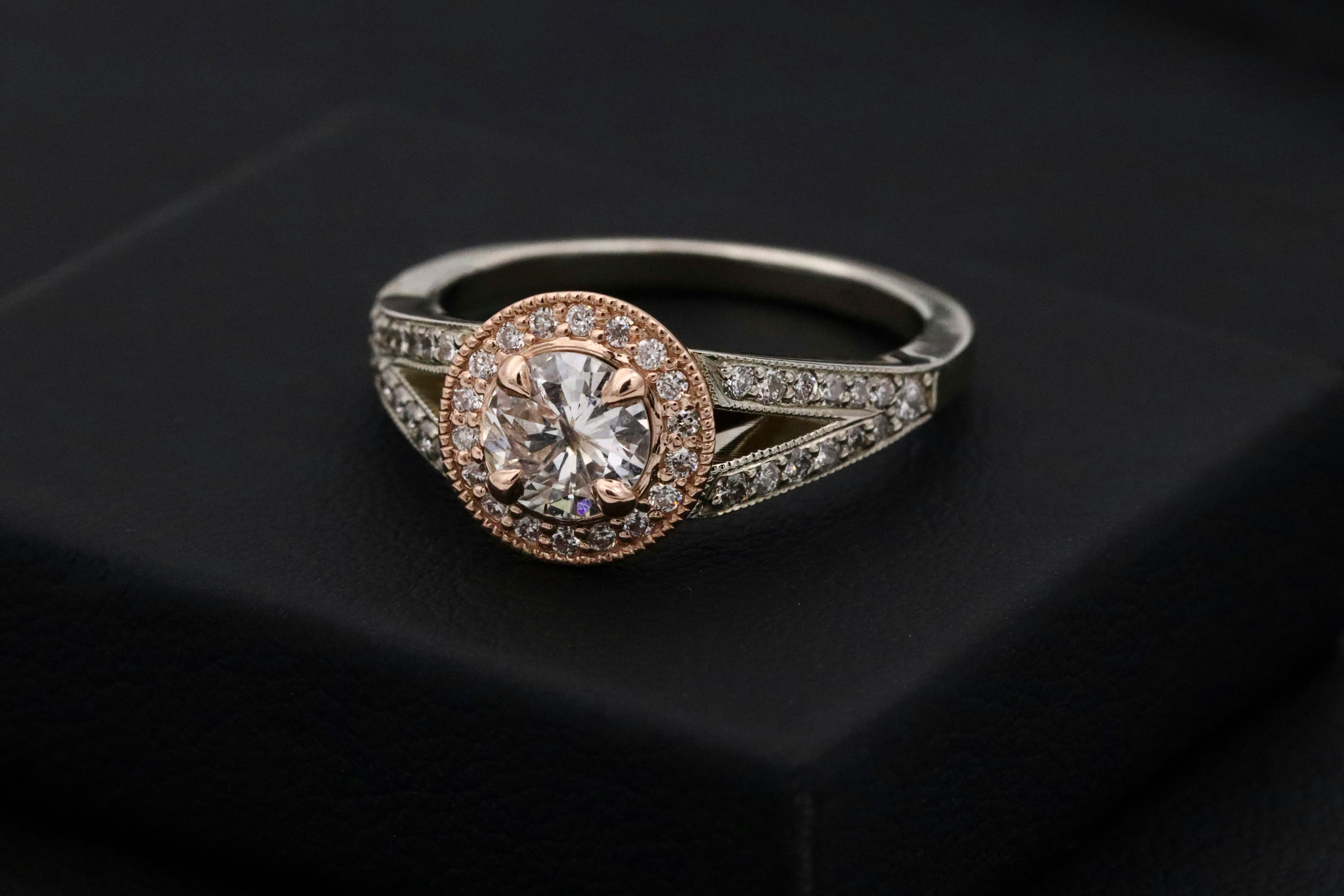 A diamond ring photographed close on dark stone