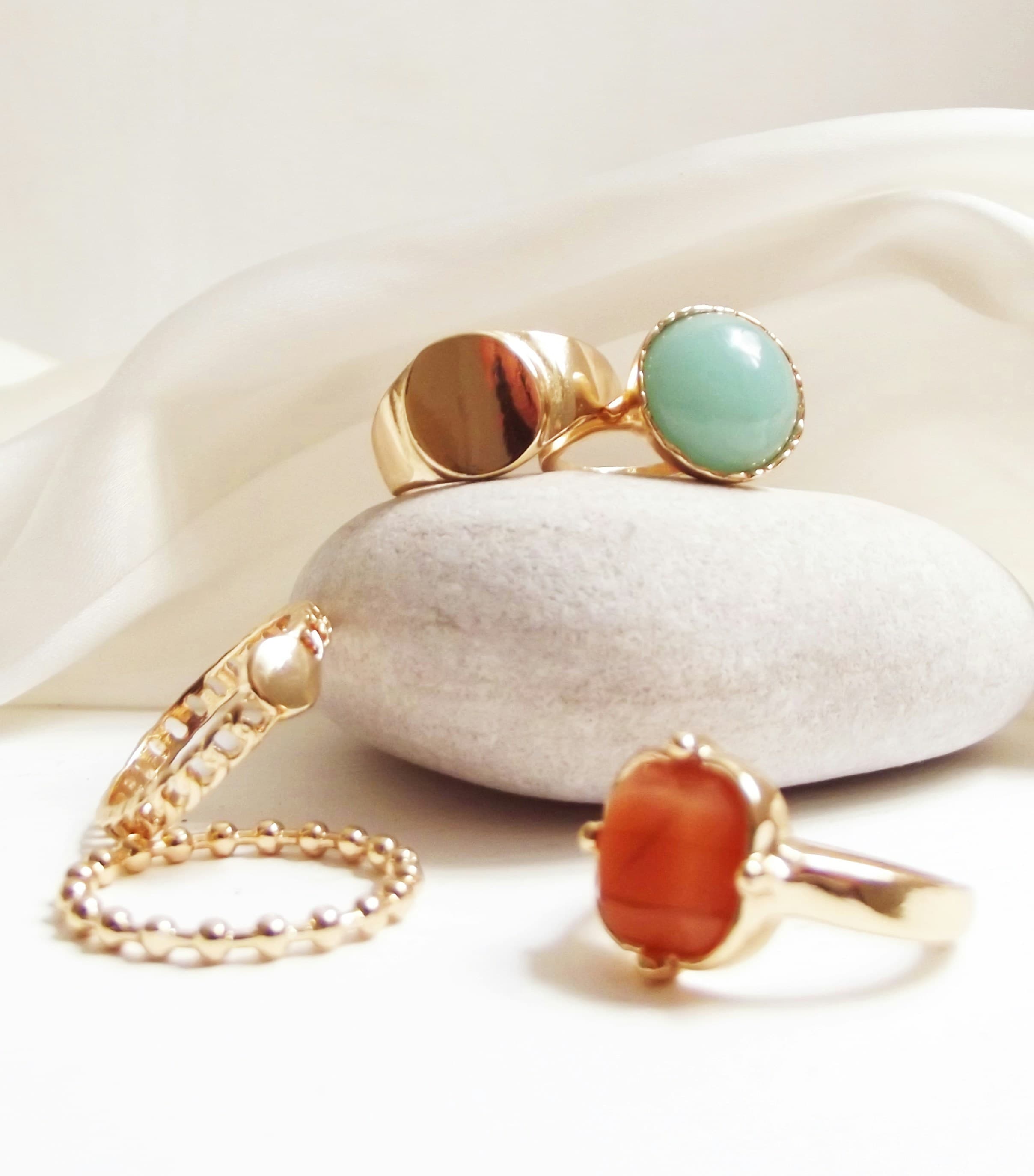 Gold pieces and coloured stones arranged on silk